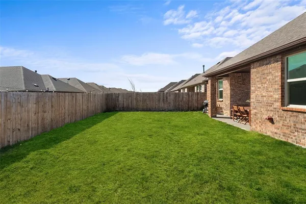 a view of a backyard with plants and wooden fence