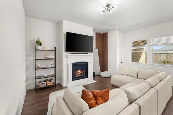 a living room with furniture a fireplace and a flat screen tv