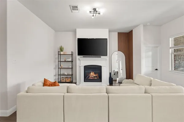 a living room with furniture a flat screen tv and a fireplace