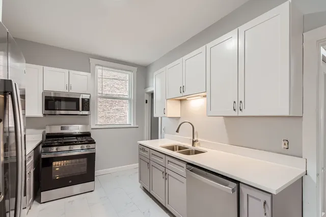 a kitchen with stainless steel appliances a sink stove and refrigerator