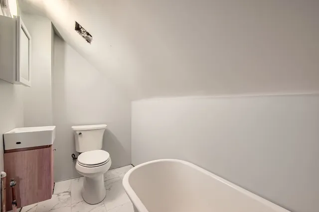 a white toilet sitting next to a white sink