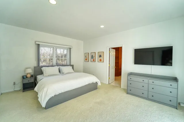 a spacious bedroom with a large bed and a flat screen tv