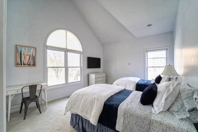 a bedroom with a bed and a large window