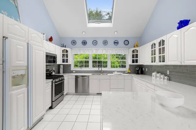 a kitchen with stainless steel appliances granite countertop a stove a sink and a refrigerator