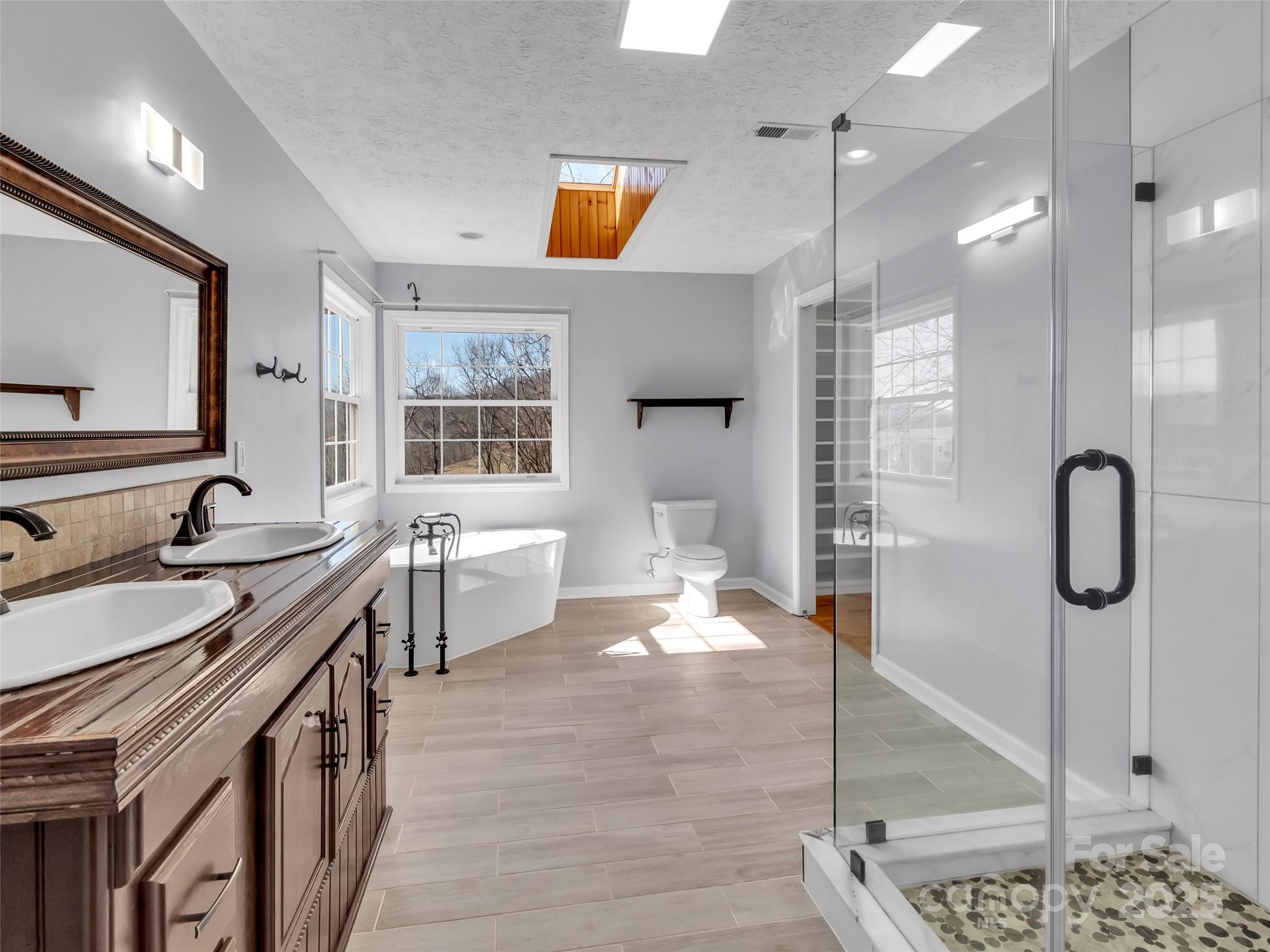 235 Loop Road Clyde, NC 28721 - Photo 11 of 21 a spacious bathroom with a double vanity sink a mirror and a shower