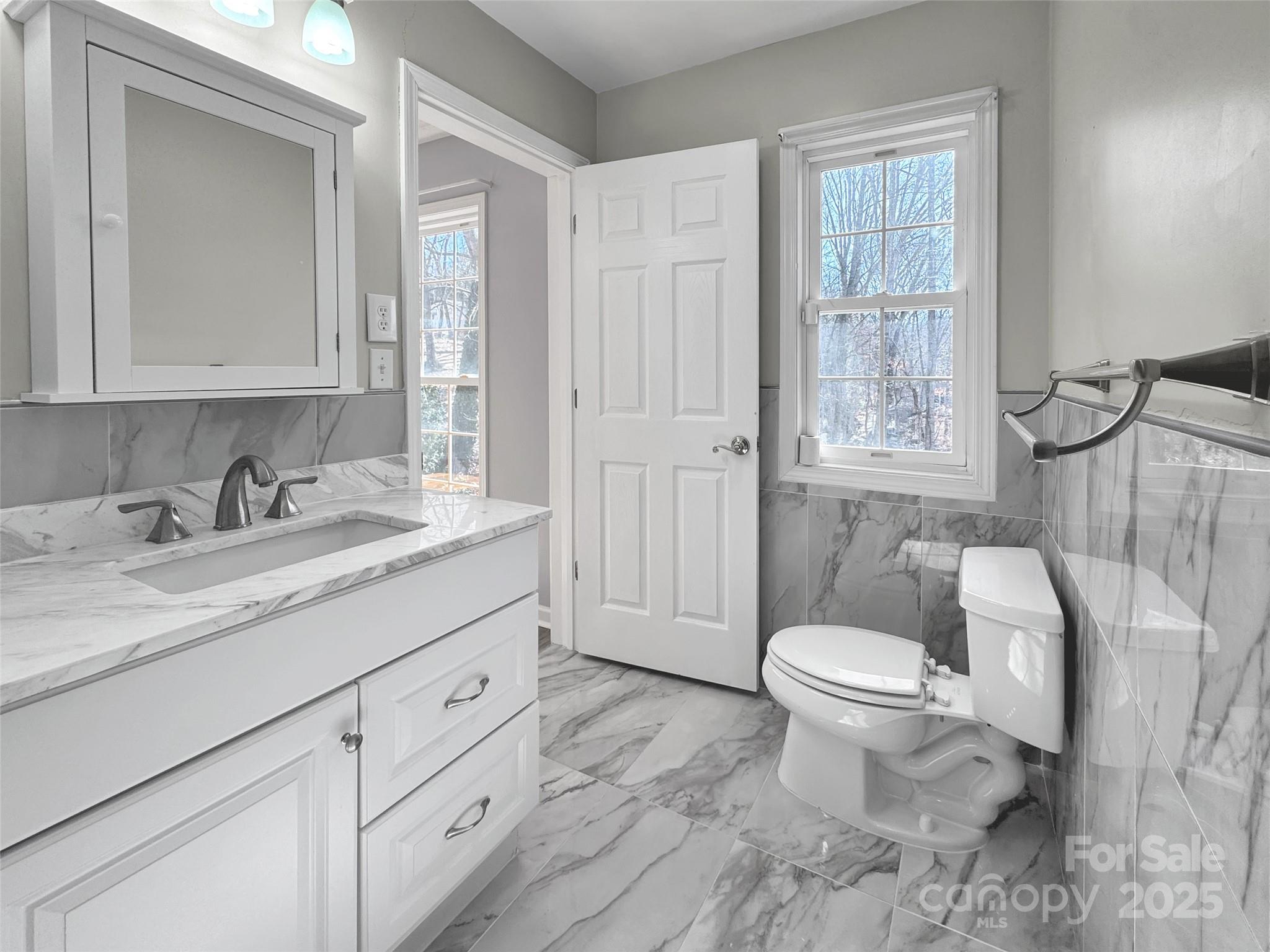 235 Loop Road Clyde, NC 28721 - Photo 15 of 21 a bathroom with a granite countertop toilet sink and mirror