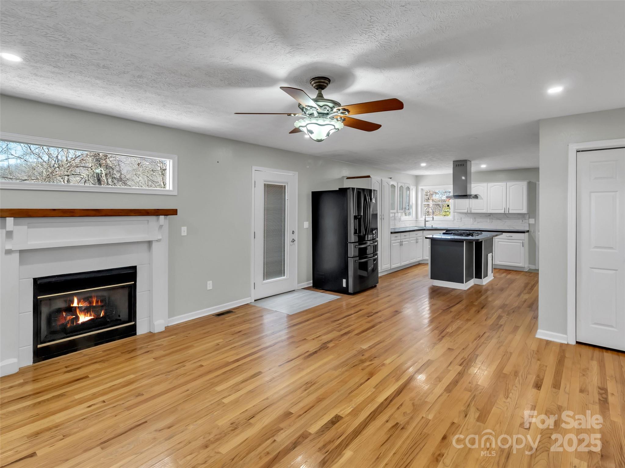 235 Loop Road Clyde, NC 28721 - Photo 7 of 21 a view of a kitchen and an empty room with a fireplace