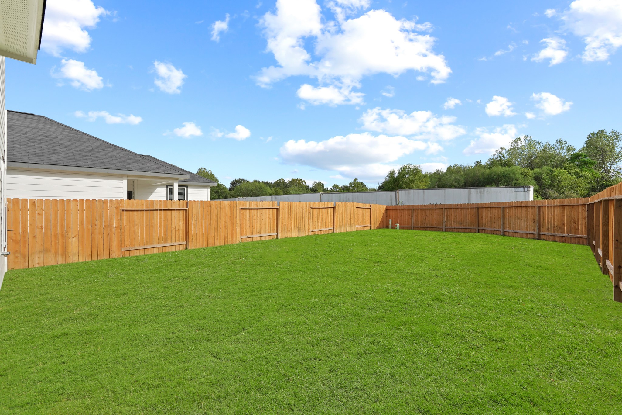 1407 Acorn Meadow Street Houston, TX 77067 - Photo 18 of 22 a view of a backyard with grass and a garage