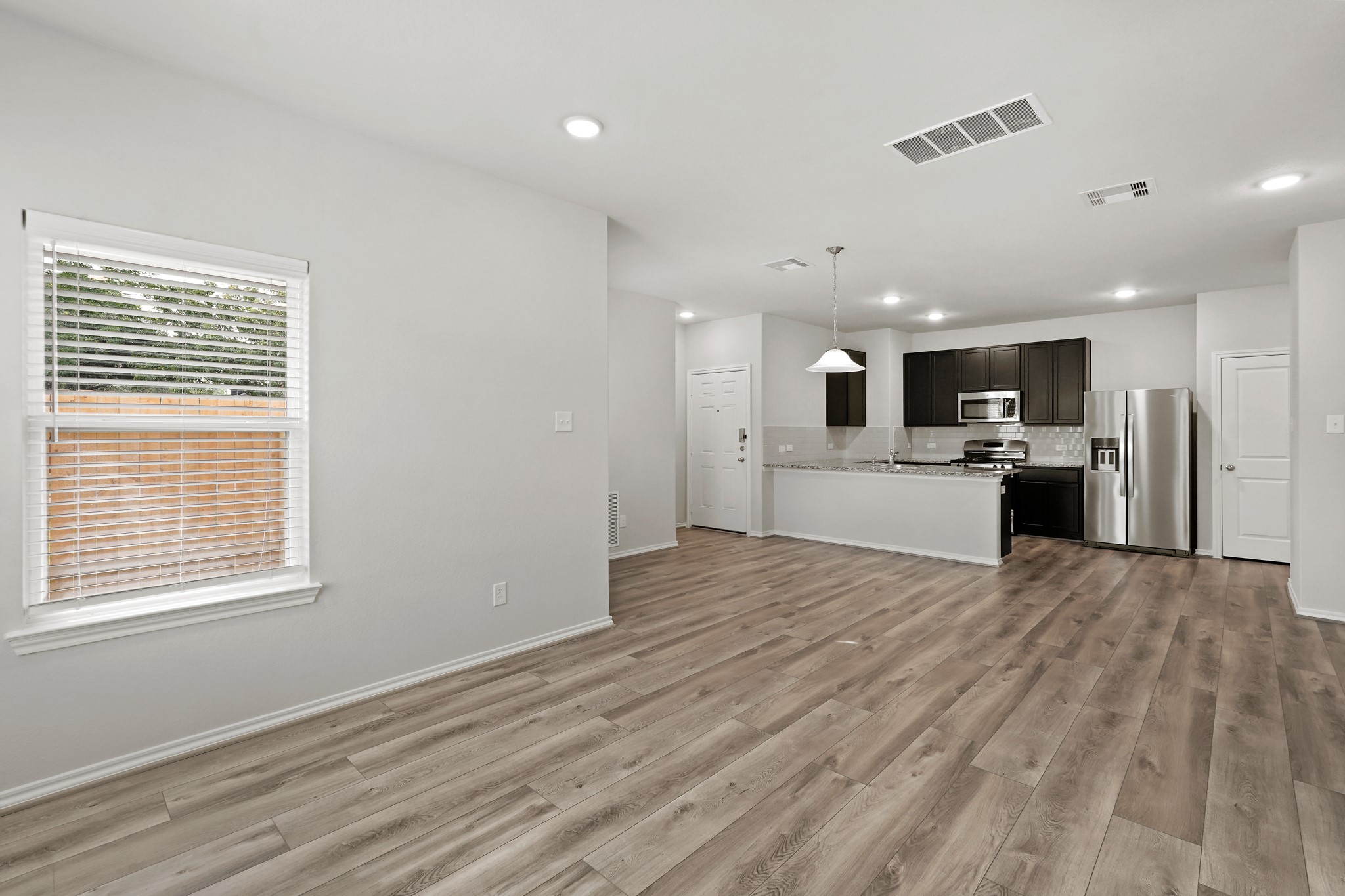 1407 Acorn Meadow Street Houston, TX 77067 - Photo 7 of 22 a view of a kitchen with a sink dishwasher stove and refrigerator with wooden floor