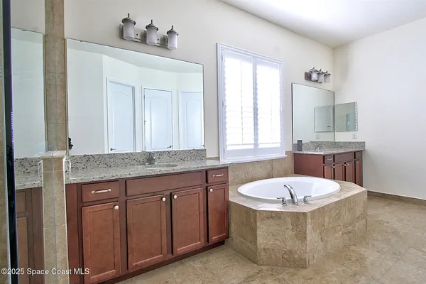 a bathroom with a tub a sink and a window