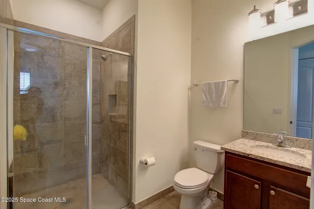 a bathroom with a granite countertop sink toilet and shower