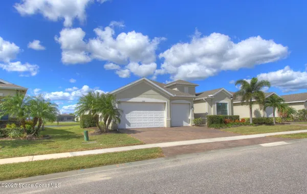 a front view of a house with a garden and yard