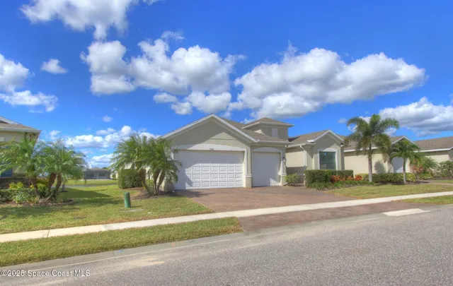 a front view of a house with a garden and yard