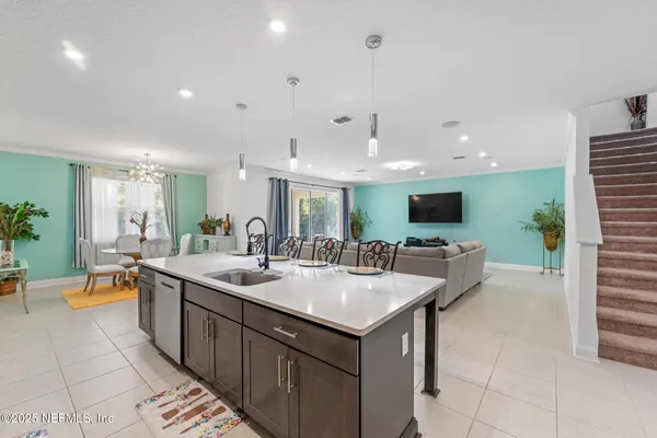 a large kitchen with kitchen island a sink a counter top space and living room view