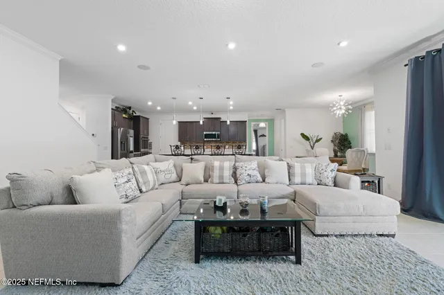 a living room with furniture and a view of kitchen