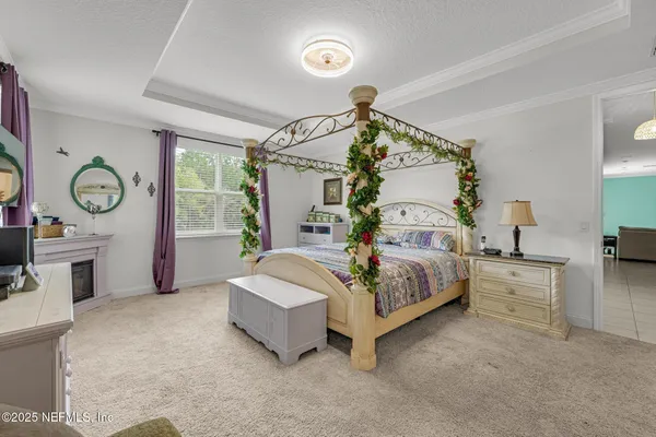 a spacious bedroom with a bed and a chandelier