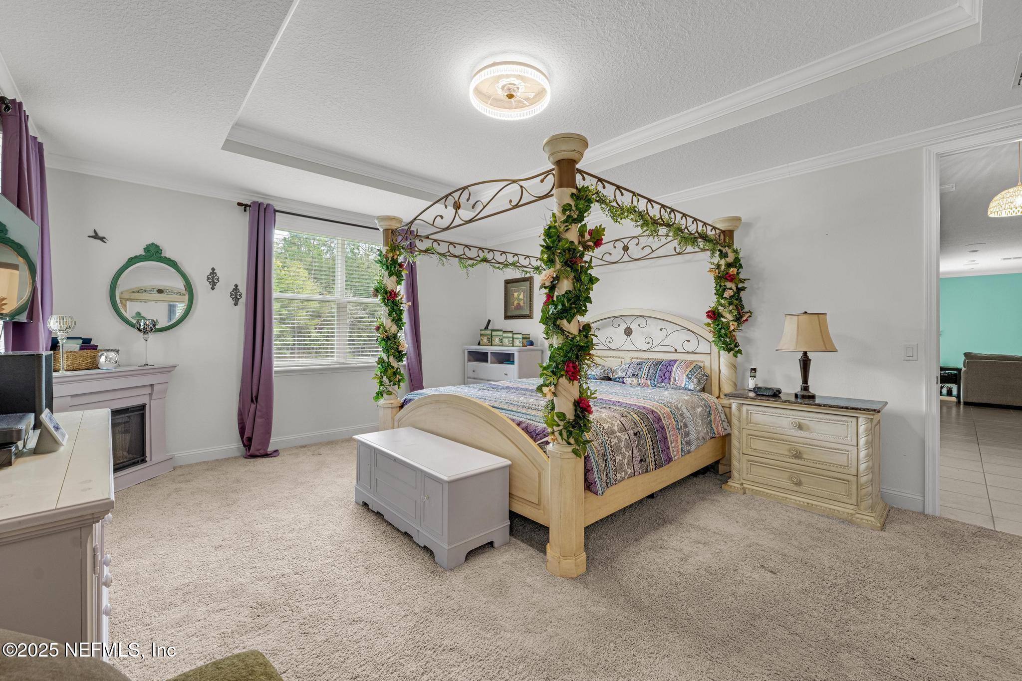 1465 Lake Foxmeadow Road Middleburg, FL 32068 - Photo 19 of 45 a spacious bedroom with a bed and a chandelier