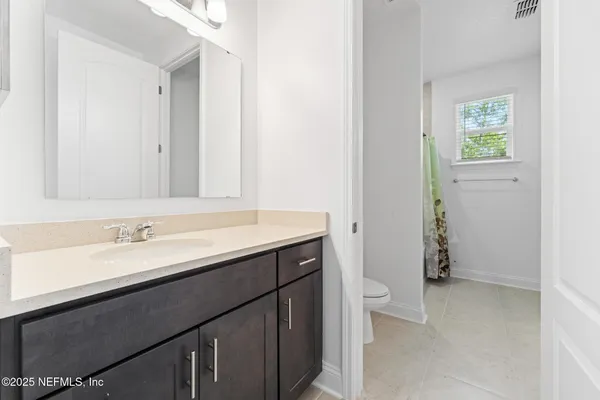 a bathroom with a sink a toilet and a mirror
