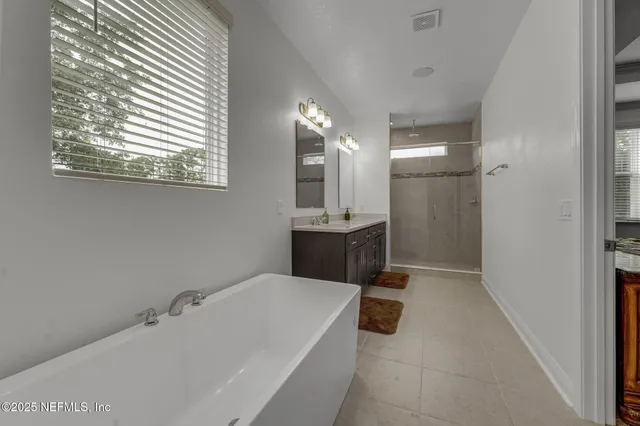 a bathroom with a tub a sink and a mirror