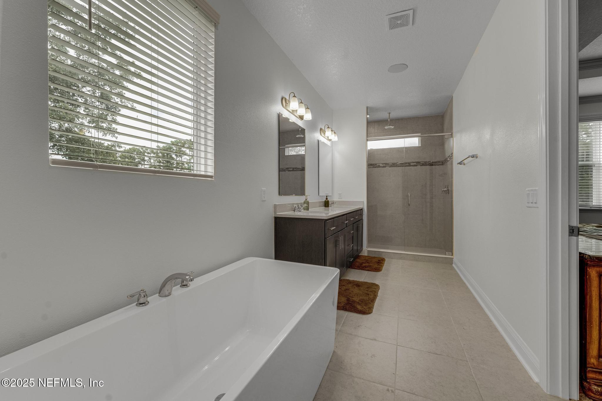 1465 Lake Foxmeadow Road Middleburg, FL 32068 - Photo 38 of 45 a bathroom with a tub a sink and a mirror