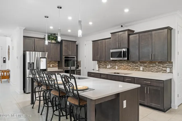 a kitchen with stainless steel appliances kitchen island granite countertop a kitchen island and chairs in it