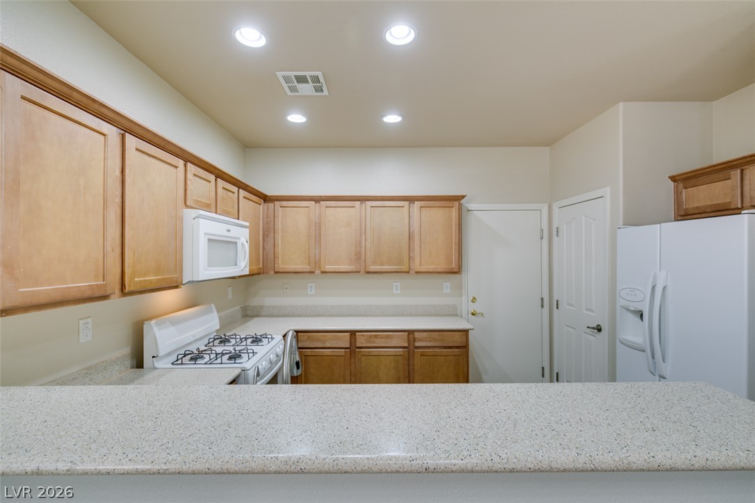 8937 Caledon Ridge Court Las Vegas, NV 89149 - Photo 21 of 43 A well-equipped kitchen featuring ample counter space and natural wood cabinetry.