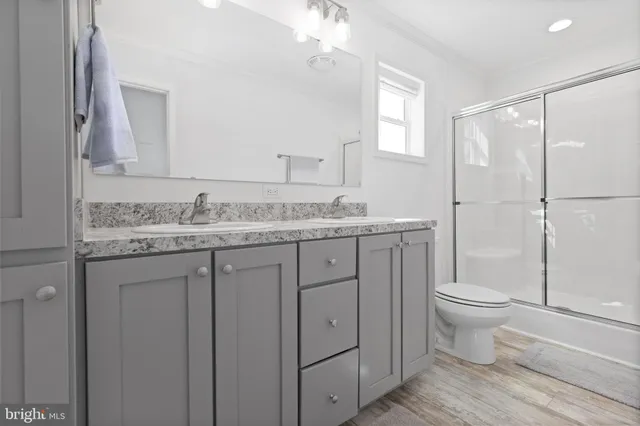 a bathroom with a granite countertop sink toilet and shower
