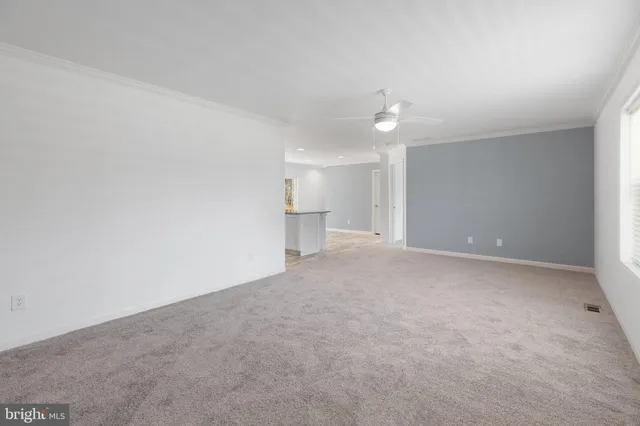 a view of a big room with a ceiling fan and entryway