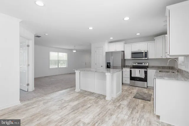 a kitchen with granite countertop a refrigerator and a stove top oven