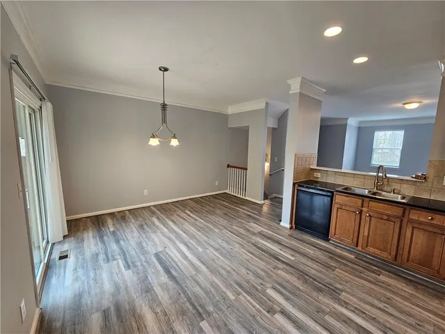 a kitchen with stainless steel appliances granite countertop a refrigerator a stove and a wooden floors