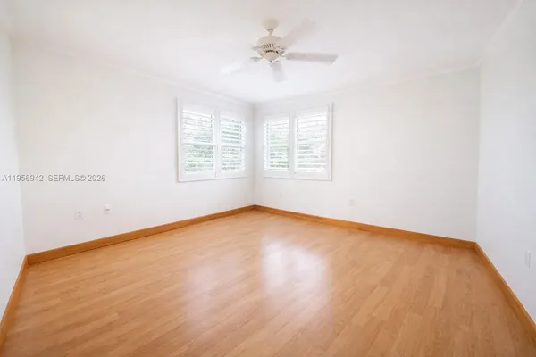 an empty room with a window and a ceiling fan