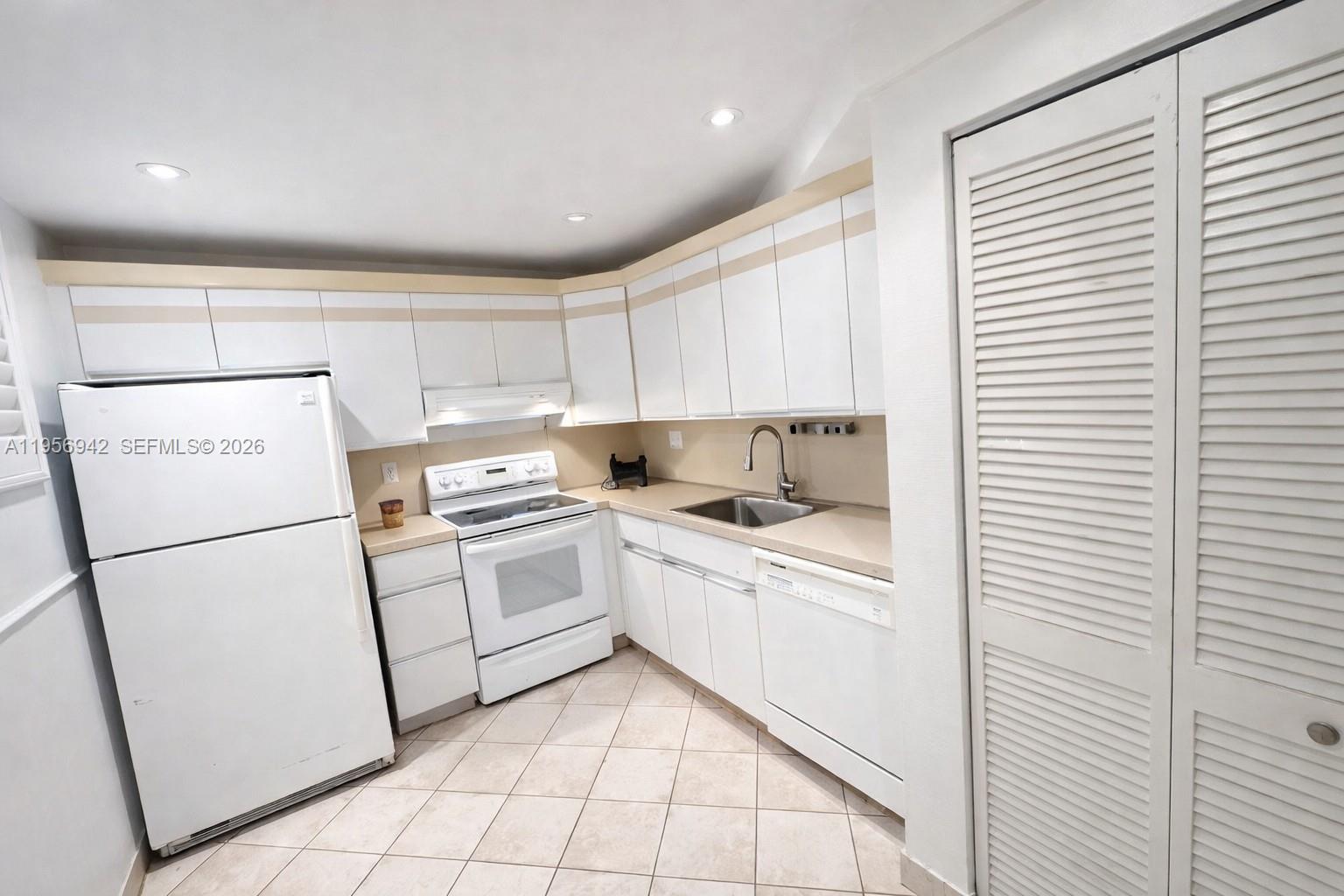 3920 Inverrary Boulevard, Unit 608C Lauderhill, FL 33319 - Photo 2 of 14 a kitchen with a sink a refrigerator and cabinets