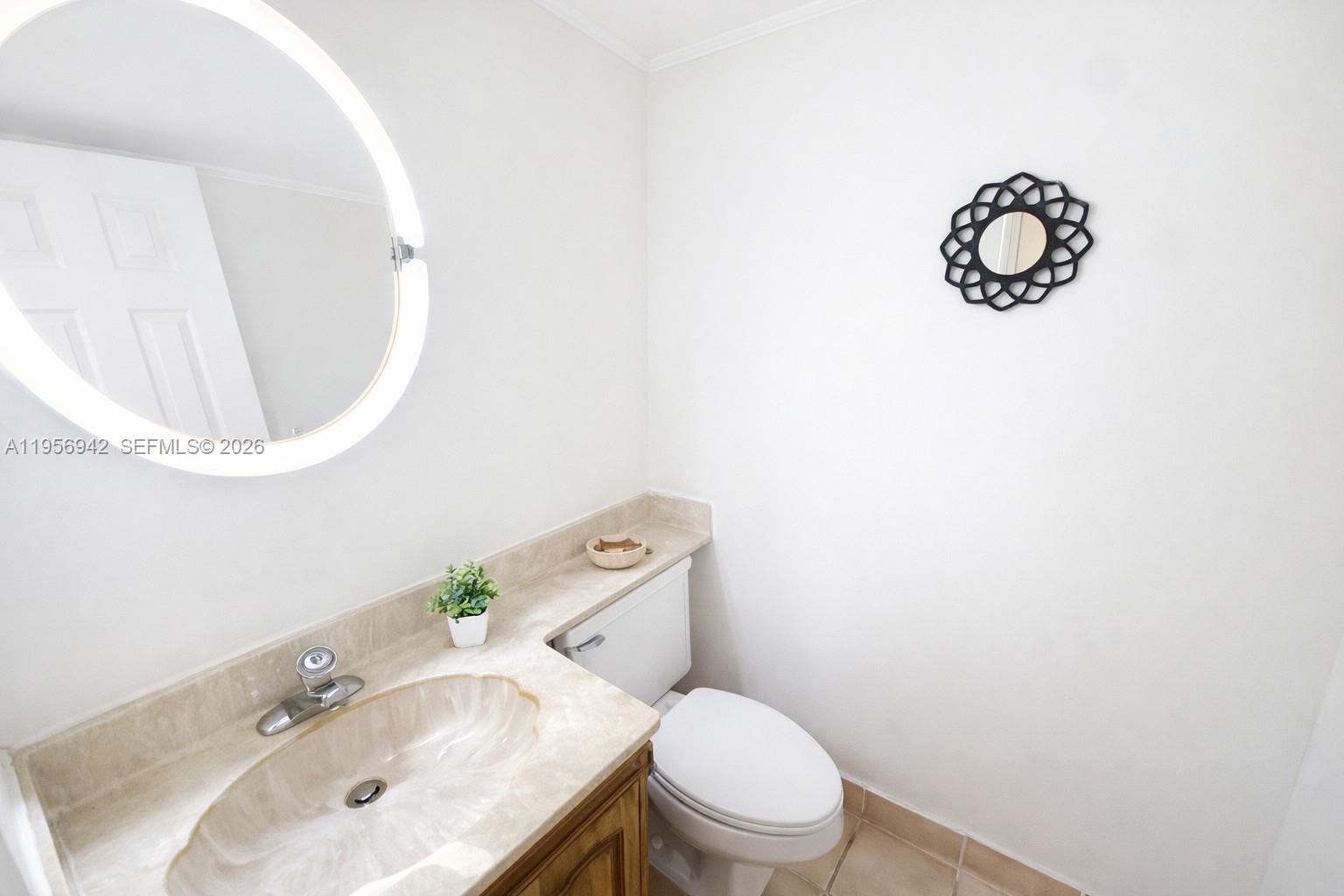 3920 Inverrary Boulevard, Unit 608C Lauderhill, FL 33319 - Photo 5 of 14 a bathroom with a toilet sink vanity and mirror