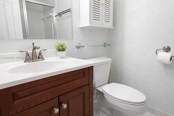 a bathroom with a sink a toilet and mirror