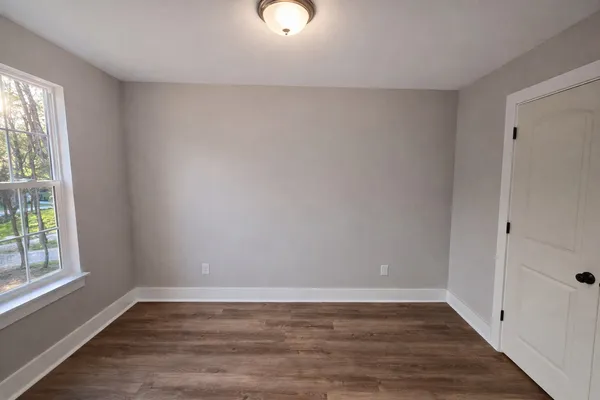 wooden floor in an empty room with a window