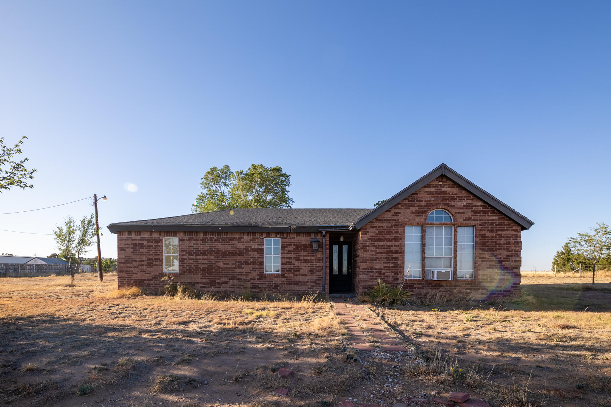 6917 Highway 114 Lubbock, TX 79407 - Photo 2 of 45 a front view of a house with a yard