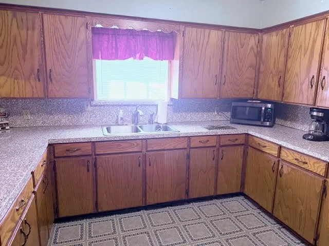 a kitchen with a sink cabinets and window