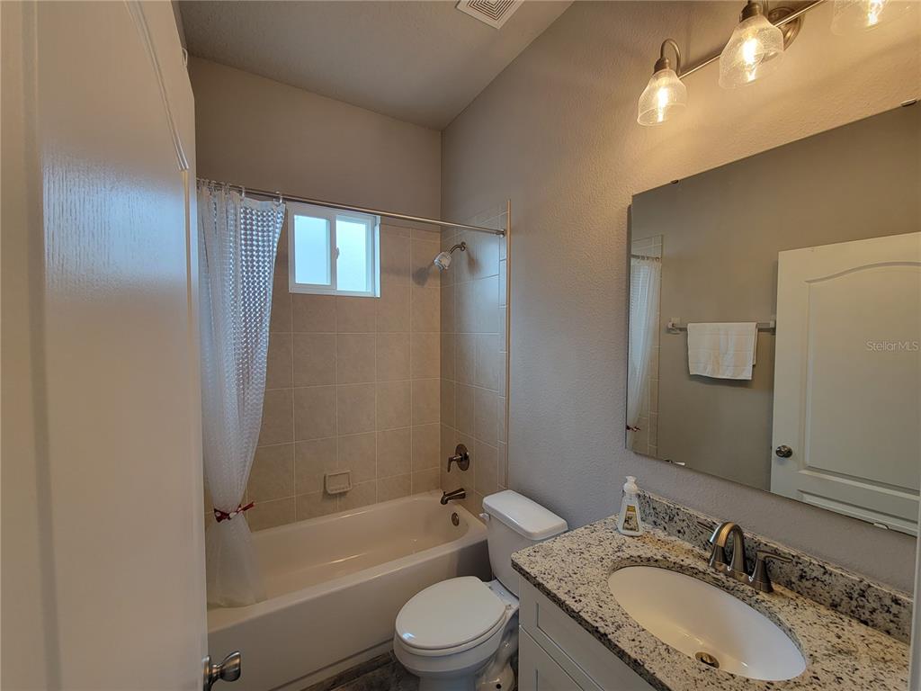 6323 Southwest 47th Terrace Gainesville, FL 32608 - Photo 21 of 25 a bathroom with a granite countertop sink toilet mirror and shower