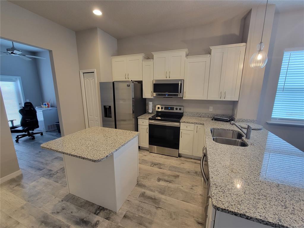 6323 Southwest 47th Terrace Gainesville, FL 32608 - Photo 6 of 25 a kitchen with stainless steel appliances granite countertop a sink stove and refrigerator