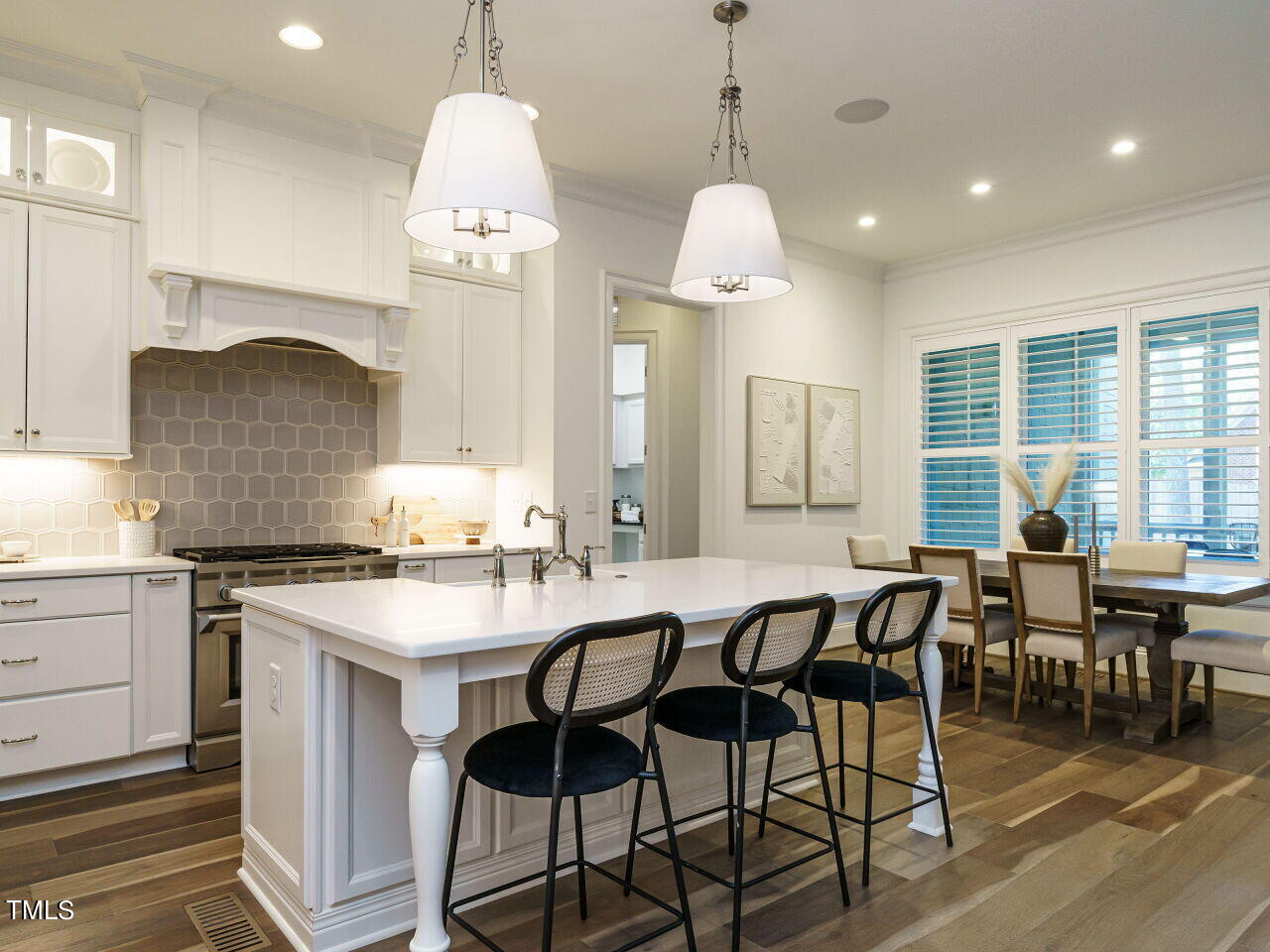 4405 Boxwood Road Raleigh, NC 27612 - Photo 11 of 58 a kitchen with a dining table chairs stainless steel appliances and cabinets