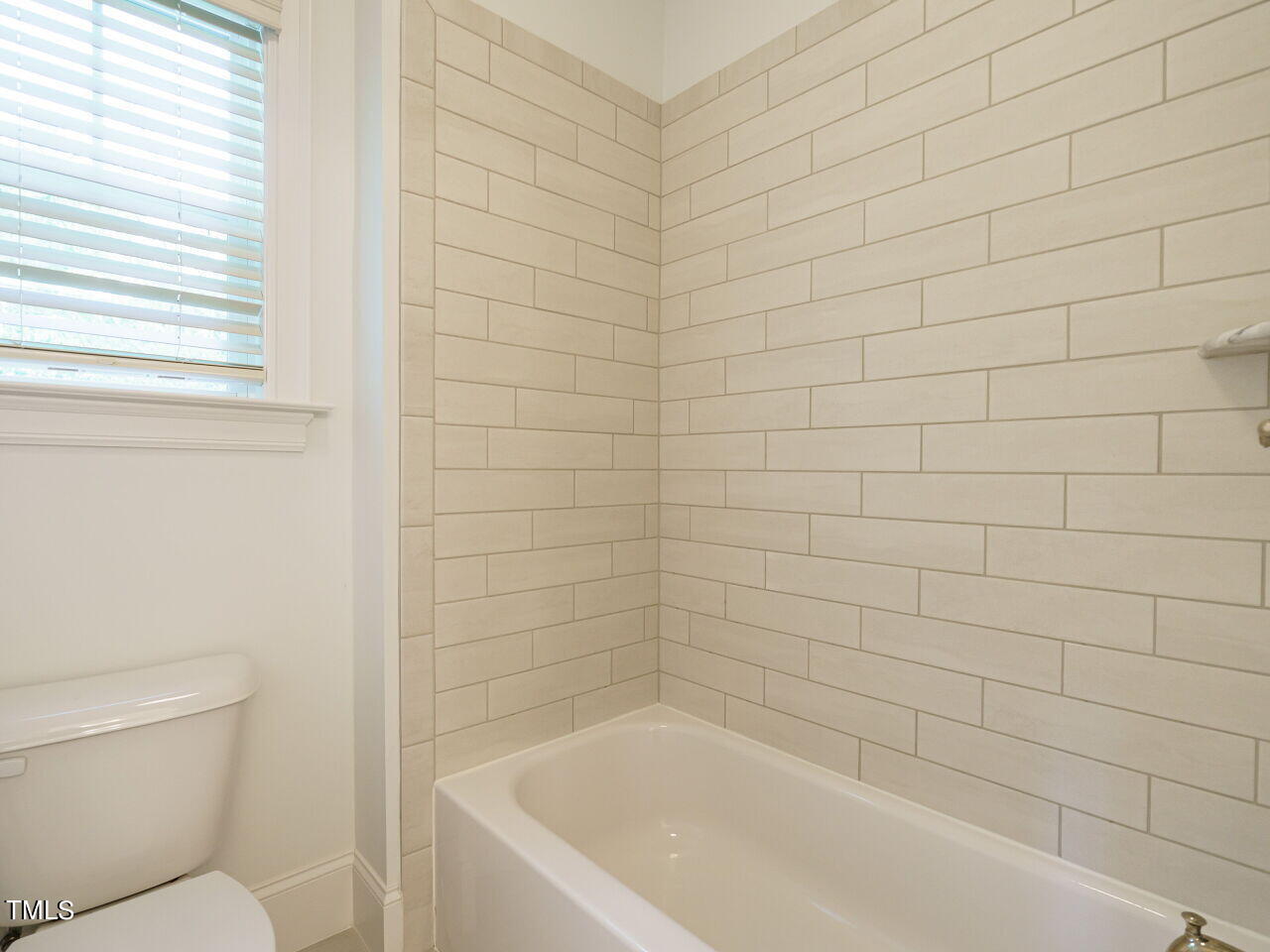 4405 Boxwood Road Raleigh, NC 27612 - Photo 31 of 58 a bathroom with a bathtub and toilet
