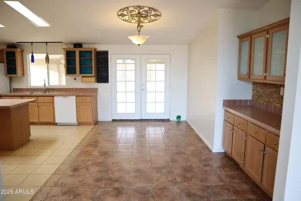 an empty room with wooden floor chandelier fan and windows