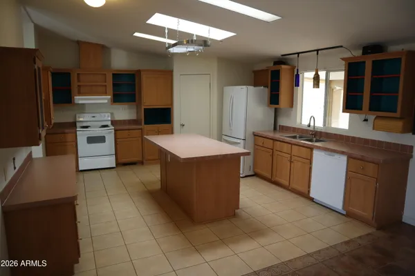 a large kitchen with stainless steel appliances granite countertop a sink counter space cabinets and a large window