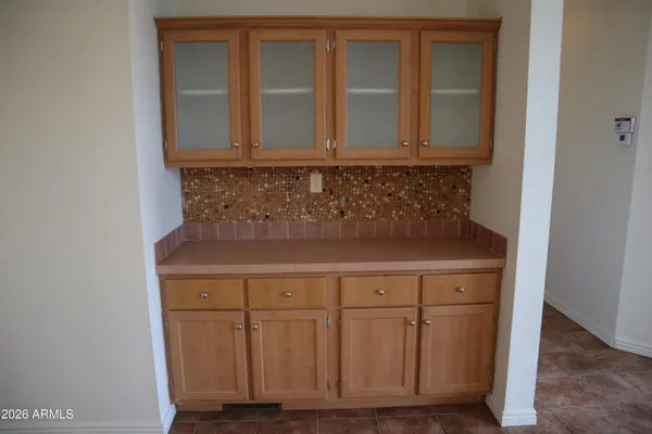 an empty room with chandelier fan and windows