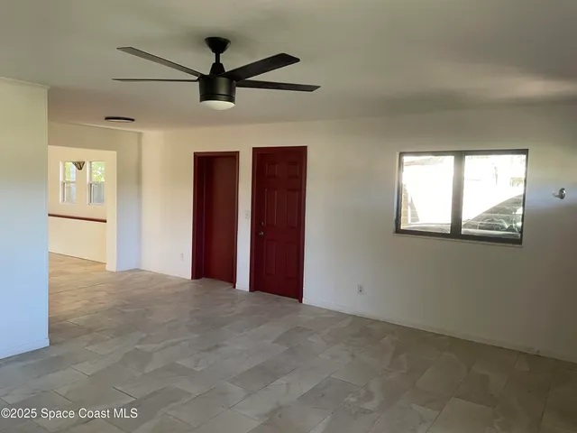 a view of a livingroom with a ceiling fan and window