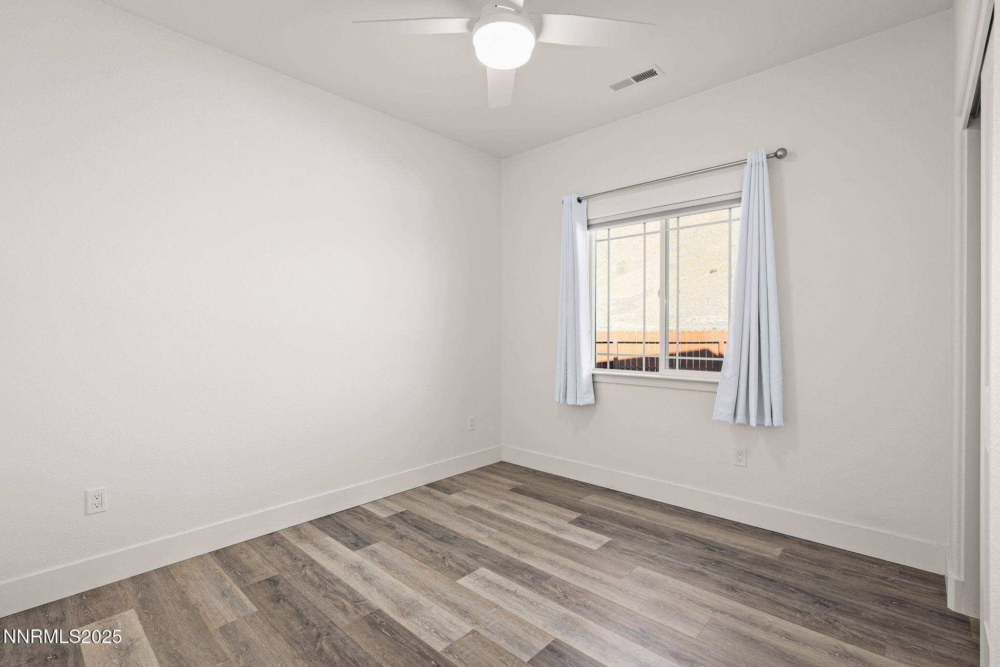 1075 West Slab Cliffs Reno, NV 89508 - Photo 11 of 22 an empty room with wooden floor and windows