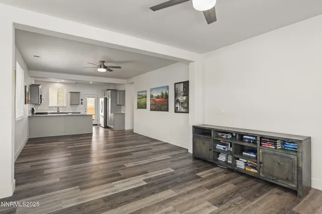 a view of an empty room with window and wooden floor