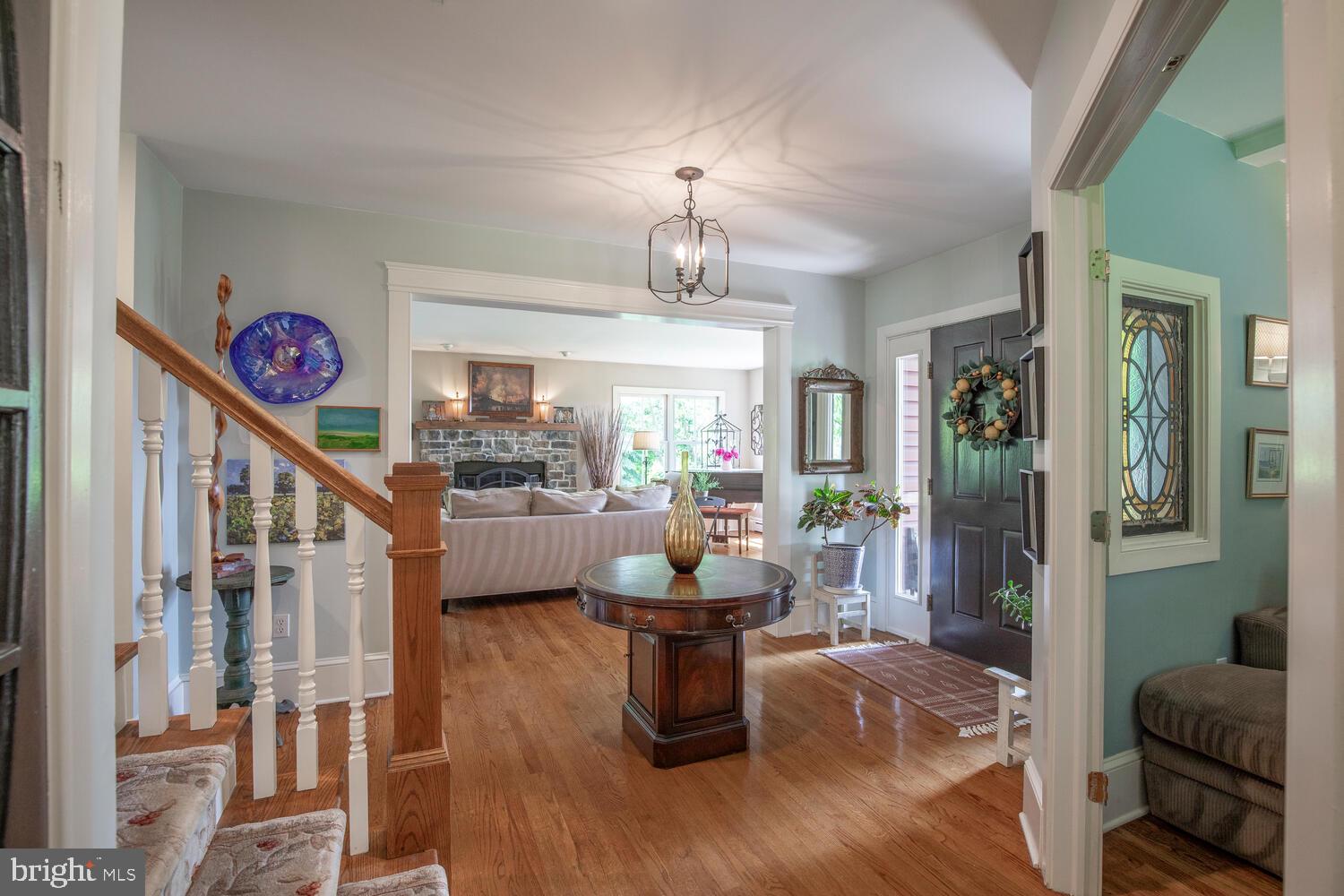 4367 Curly Hill Road Doylestown, PA 18902 - Photo 6 of 72 a living room with furniture a chandelier and a fireplace
