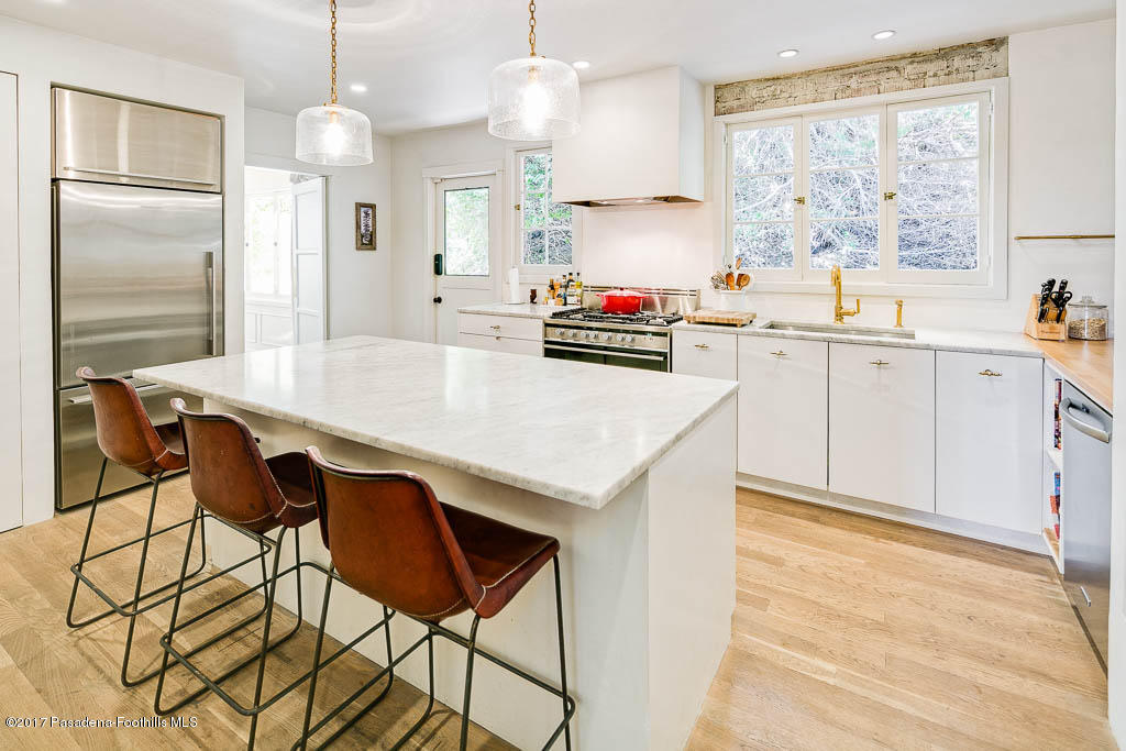 1336 Inverness Drive Pasadena, CA 91103 - Photo 17 of 42 a kitchen with stainless steel appliances kitchen island a table chairs in it and white cabinets