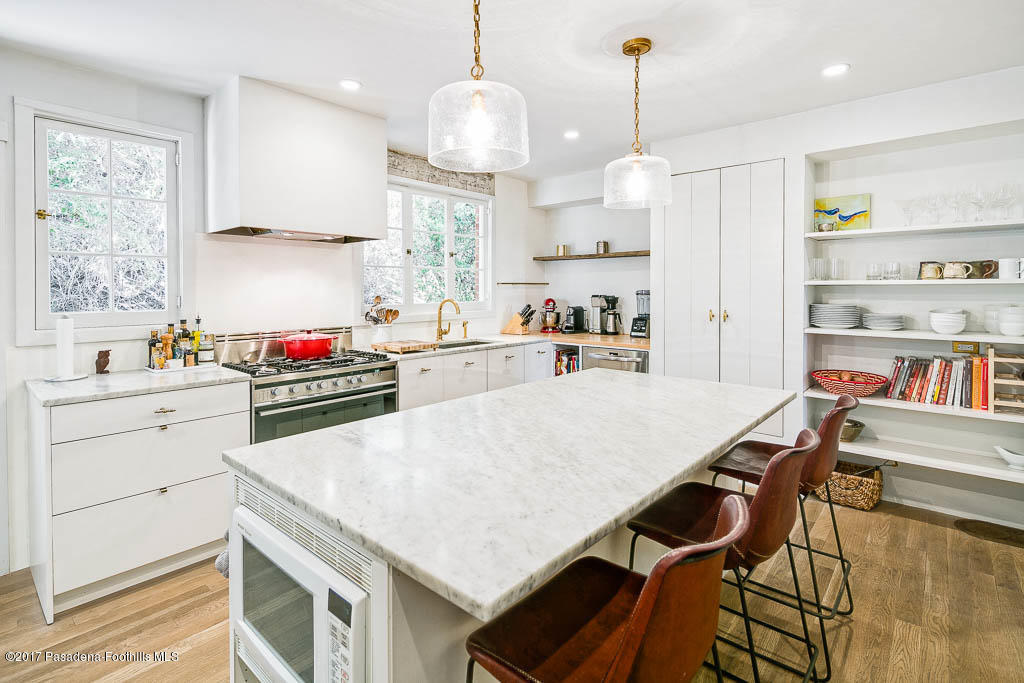 1336 Inverness Drive Pasadena, CA 91103 - Photo 18 of 42 a kitchen with kitchen island a stove a table and chairs in it